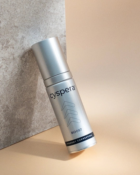 Cyspera Boost lifestyle bottle on neutral backdrop for pigment correction, radiance and smoother-looking uneven facial skin.