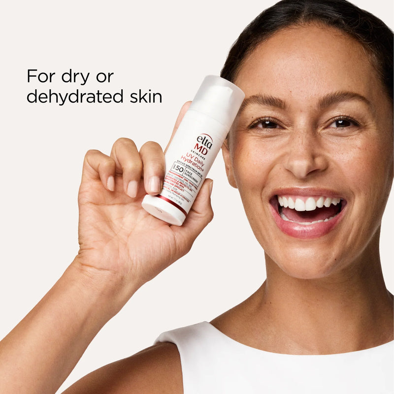 Smiling model holding EltaMD UV Hydration+ SPF 50 face sunscreen for dry or dehydrated skin on beige background.