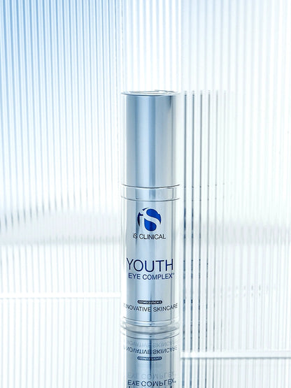 iS Clinical Youth Eye Complex silver bottle on reflective glass background for hydrating under eye treatment and care daily.