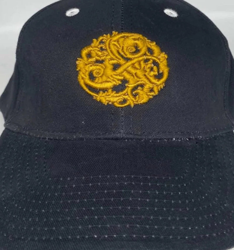 Close-up of NazarianSwag navy brushed cotton baseball cap showing gold embroidered logo and stitched brim details.
