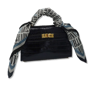Nazarian ThinkBIG silk scarf tied around a black handbag handle with bold logo print and blue border detail