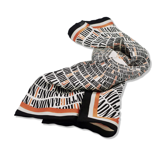 Nazarian ThinkBIG silk scarf folded with black, white, and copper typography print on a clean background