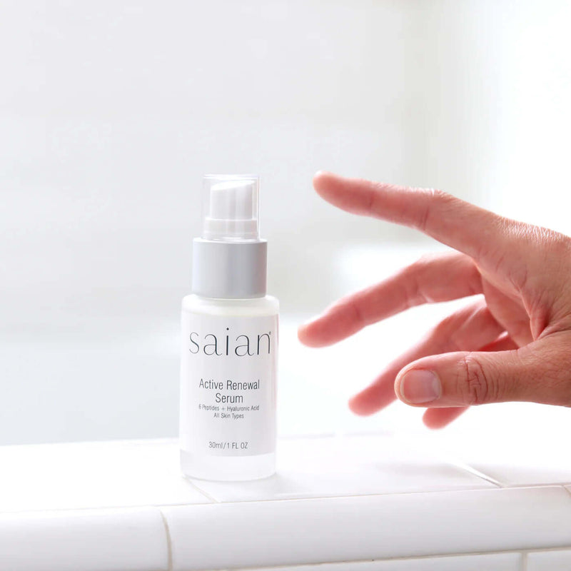 Saian Active Renewal Serum bottle on bathroom counter shows peptide and hyaluronic acid formula for daily skin renewal.