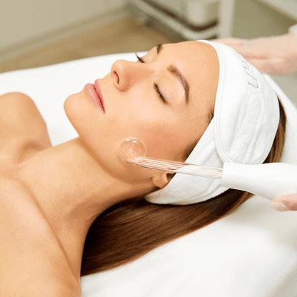 Saian High Frequency Facial Machine used with mushroom electrode on cheek during brightening facial treatment.