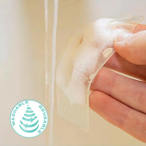 Hand washing a clear Silagen silicone scar strip under water, demonstrating that the medical-grade silicone gel sheeting is washable and reusable.