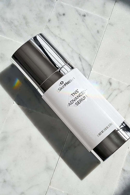 SkinMedica TNS Advanced+ Serum bottle on marble for advanced anti-aging care, smoother skin, and visible radiance daily use.