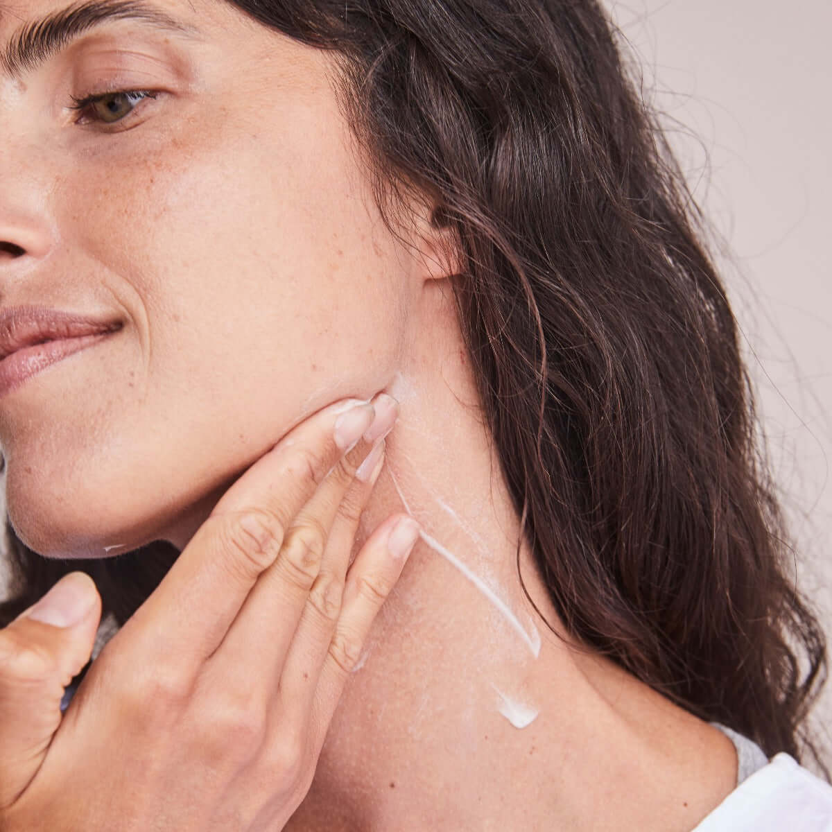 Applying Alastin Restorative Neck Complex to neck area showing neck firming cream for smoother and tighter skin
