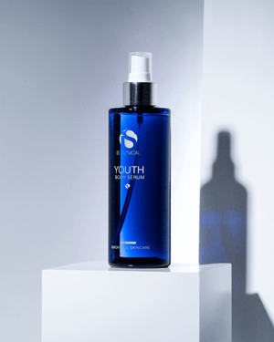 iS Clinical Youth Body Serum blue bottle on white display block with shadow for firming body hydration and smooth skin care.