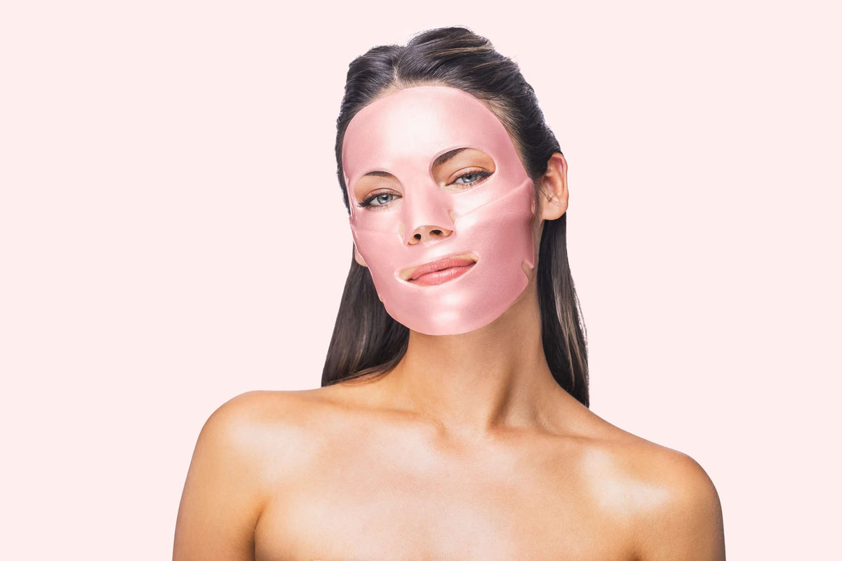 Model wearing pink Knesko collagen face mask from travel kit for radiant hydrated skin and spa like skincare at home use kit