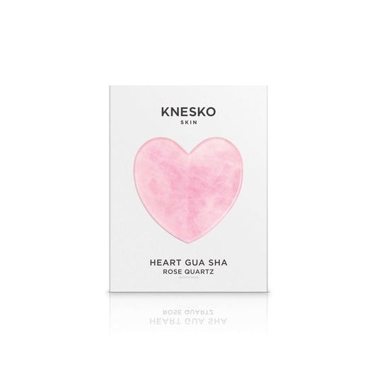 Knesko Rose Quartz Gua Sha in heart shaped box, a facial massage tool for puffiness, circulation, and natural glow care spa.