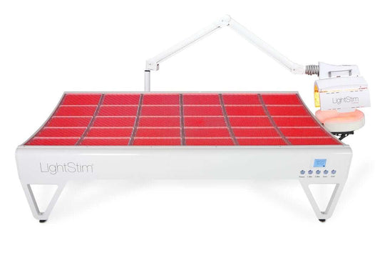 LightStim LED Bed and ProPanel full body red light therapy system with adjustable face panel and glowing LED bed in spa room