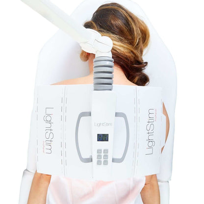 LightStim ProPanel Anti-Aging Light positioned over back for red LED therapy treatment in spa treatment chair setup care now