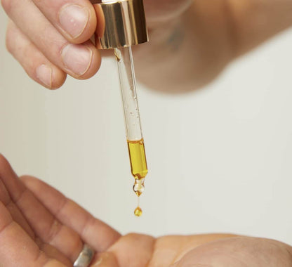 Lumity facial oil dropper close-up showing golden anti-aging oil texture for nourishing dry skin and radiance benefits daily