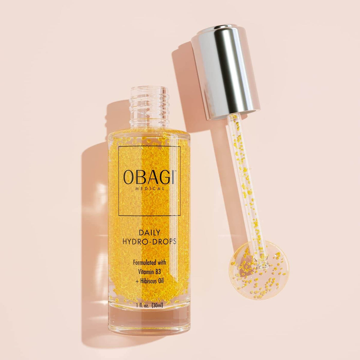 Obagi Daily Hydro-Drops bottle with pipette applicator shows Vitamin B3 and Hibiscus oil for plump, glowing skin hydration..
