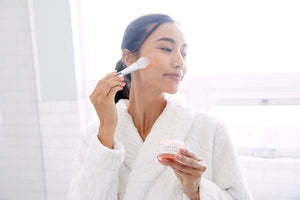Saian Pumpkin Spice Mask applied with silicone spatula by model for smooth, refreshed, radiant-looking skin care.
