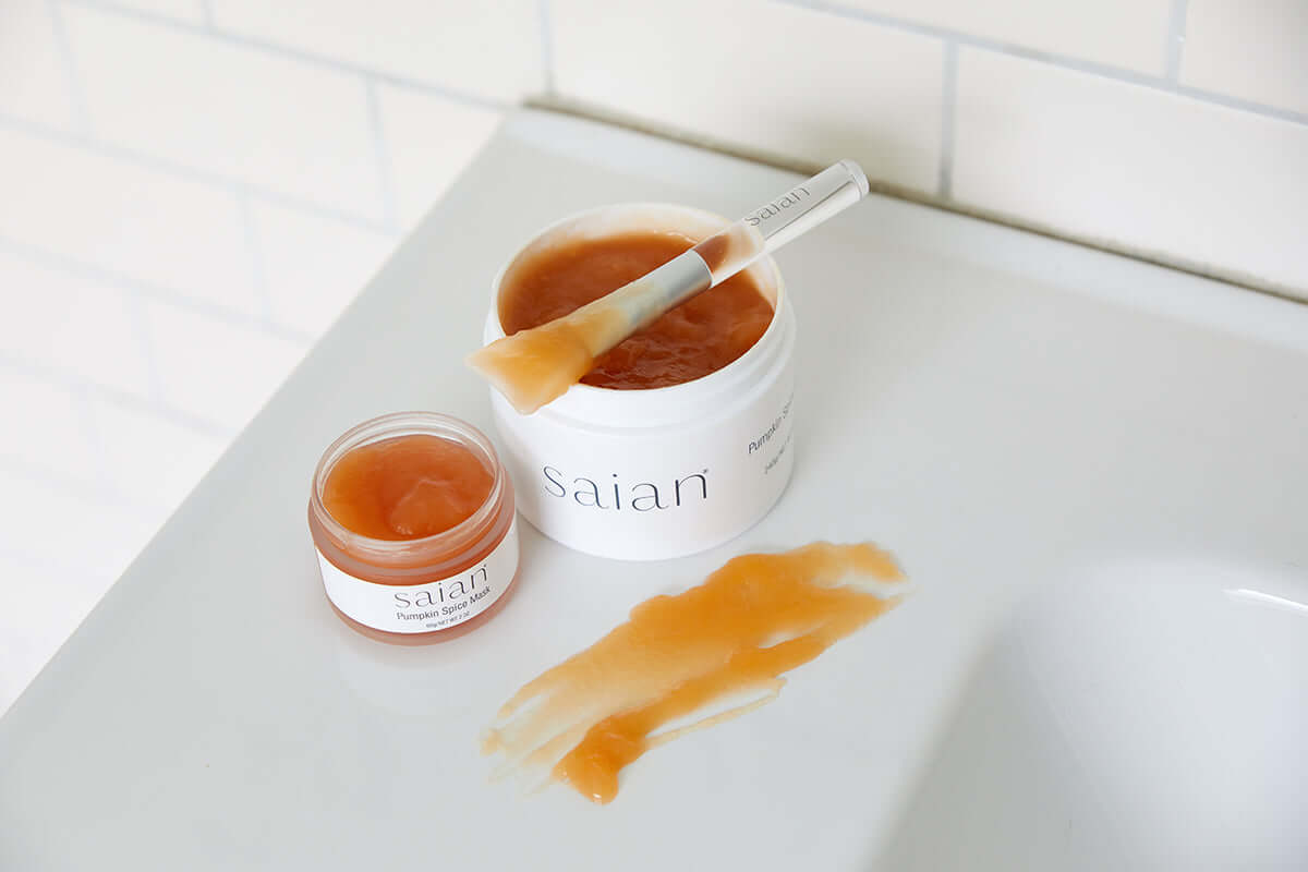 Saian Pumpkin Spice Mask jars with spatula and texture swatch for at-home exfoliating facial treatment routine.