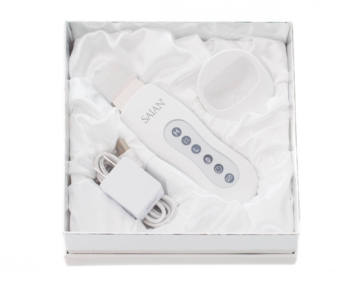 Saian Skin Scrubber Spatula kit includes device, charger, and cradle for ultrasonic exfoliation and enhanced serum use care.