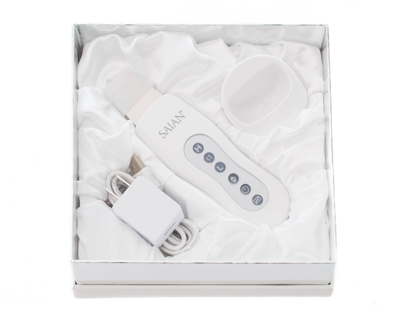 Saian Skin Scrubber Spatula kit includes device, charger, and cradle for ultrasonic exfoliation and enhanced serum use care.