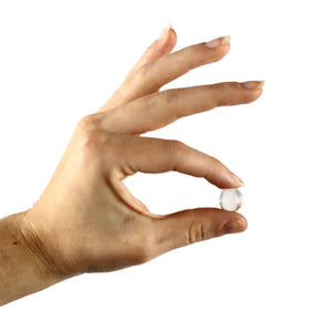 Hand holding Silagen umbilical sphere, a medical-grade silicone device designed for belly button scar coverage and support.