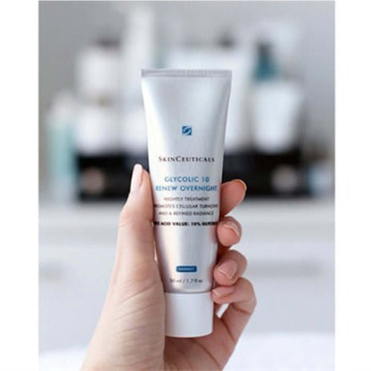 Hand holding SkinCeuticals Glycolic 10 Renew Overnight night treatment tube for smoothing and brightening skin.