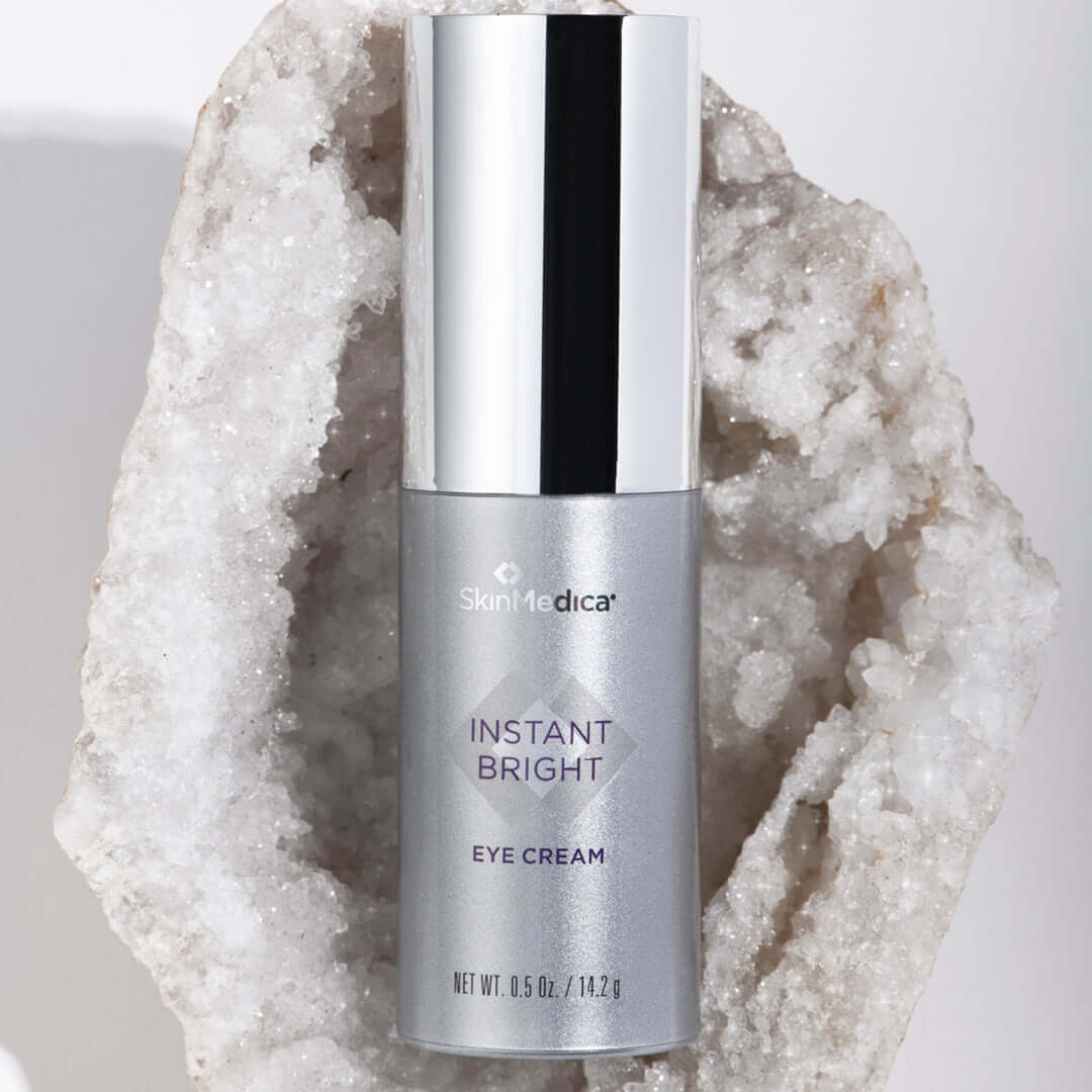 SkinMedica Instant Bright Eye Cream bottle on crystal for brightening dark circles, puffiness, smoother under-eye skin care.